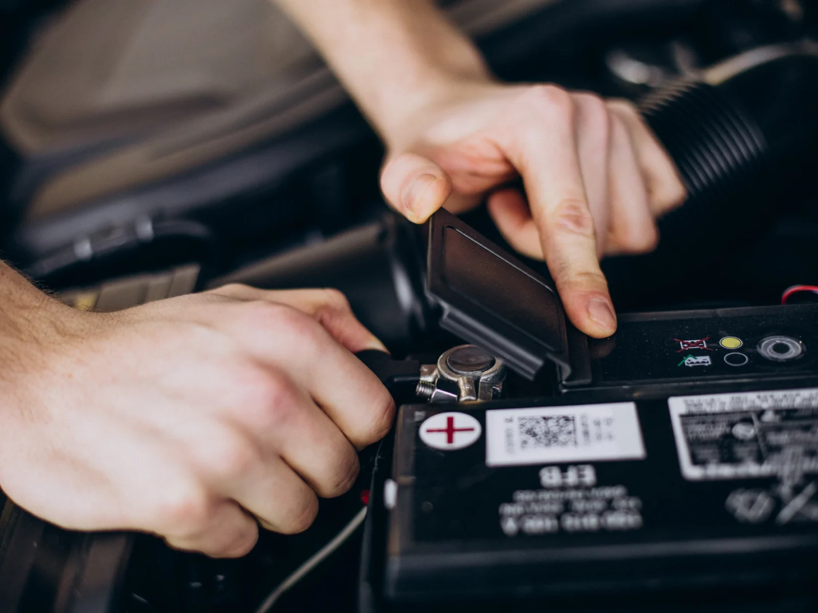 Mehaaniku käed kontrollivad auto aku klemmi